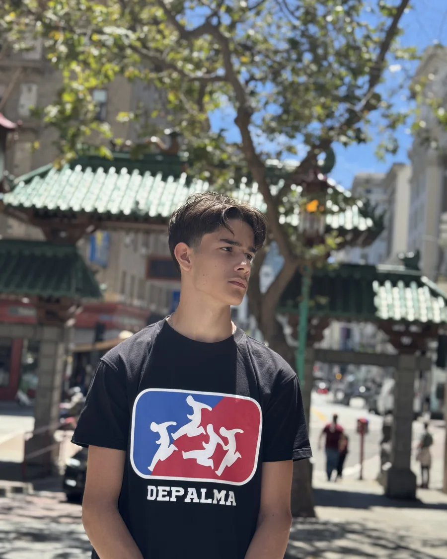 Depalma logo tee worn on a palm-lined street
